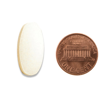 A white oval tablet being compared to the size of a penny