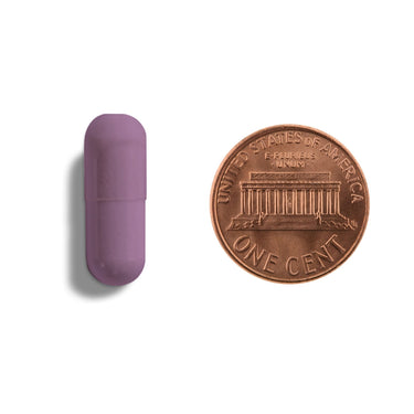 A purple capsule being compared to the size of a penny
