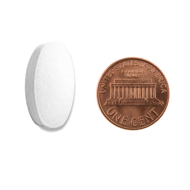 A white oval tablet being compared to the size of a penny