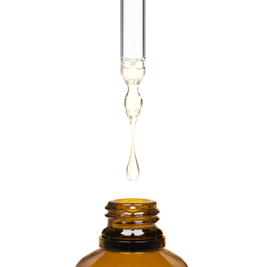 Clear liquid being dripped into an amber bottle by a dropper