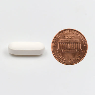 A white tablet being compared to the size of a penny