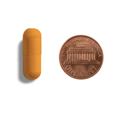 An orange capsule being compared to the size of a penny