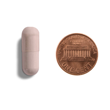 A pink capsule being compared to the size of a penny