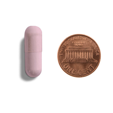 A pink capsule being compared to the size of a penny